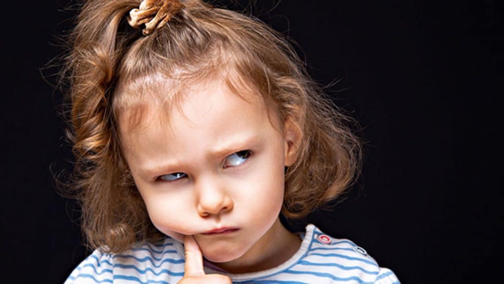 little girl puzzling about something with serious face