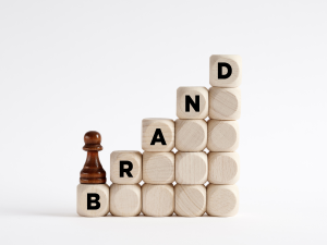 brand awareness demonstration with a tower of blocks building a staircase that spells out 'brand'. a chess piece sits at the bottom.